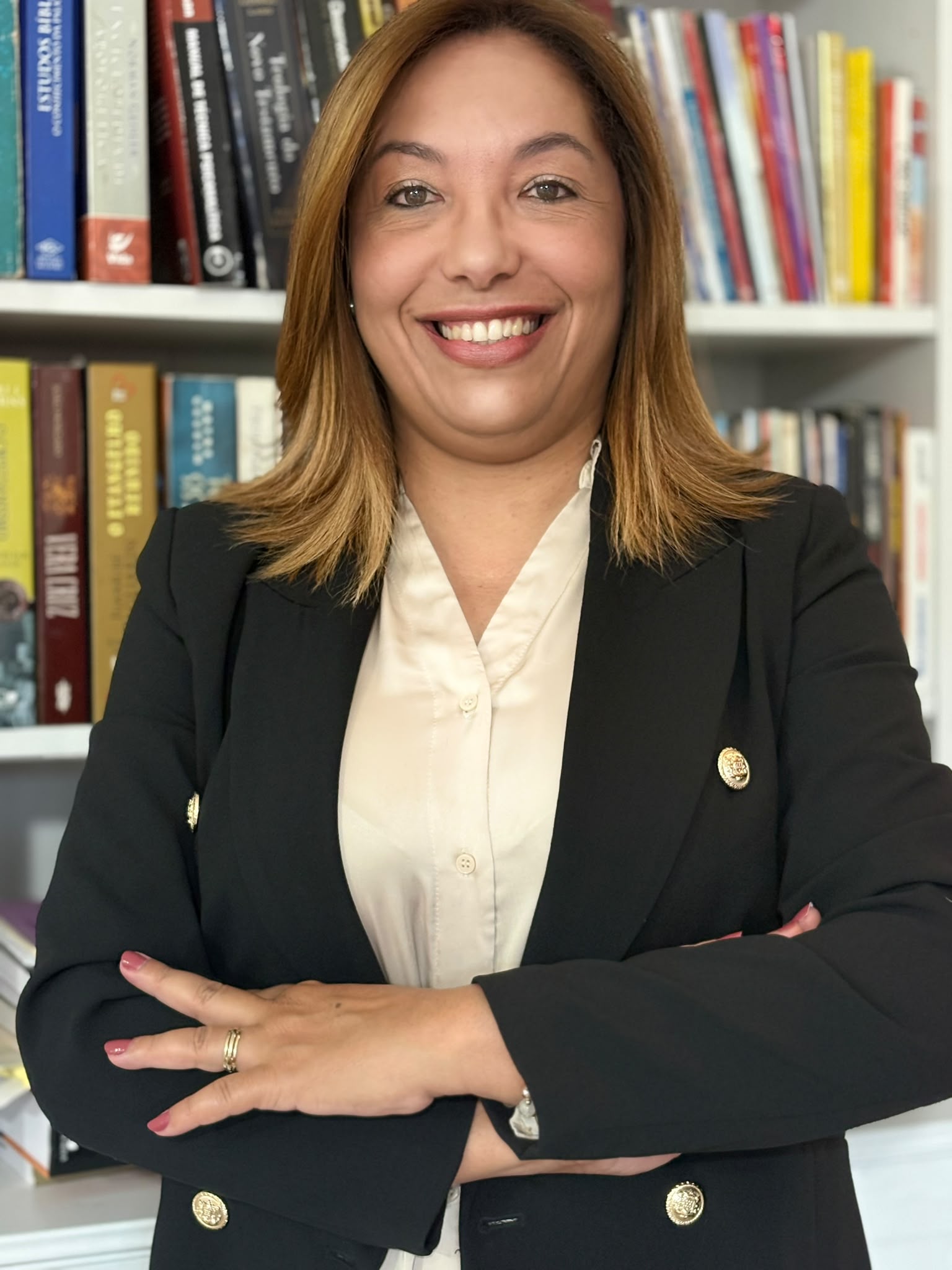 Retrato profissional de Giorgia Veloso diante de uma estante de livros